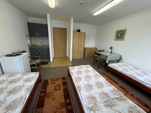 an empty room with two beds and a kitchen at Ubytovna Český Krumlov in Český Krumlov