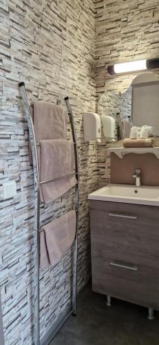 a bathroom with a towel rack next to a sink at Le Faubourg in Figeac