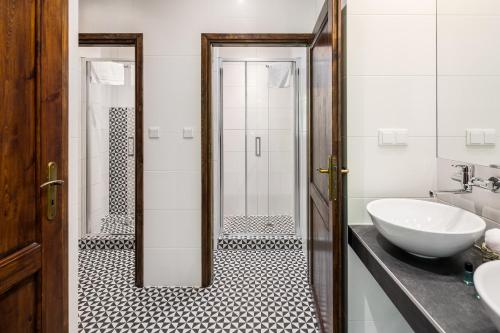 a bathroom with a white sink and a shower at Garden House Apartments in Krakow