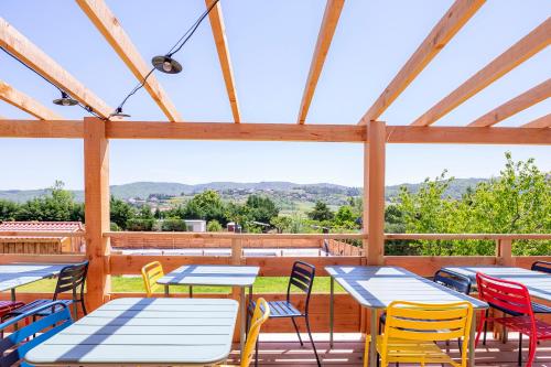 a deck with tables and chairs with a view at Dôme/insolite/parc régional du Pilat in Saint-Appolinard