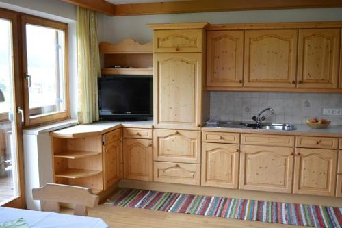 a kitchen with wooden cabinets and a sink at Schusterhof in Sankt Jakob in Haus