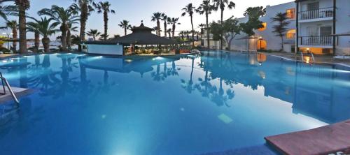 a large swimming pool with palm trees and a building at Parkim Ayaz Hotel in Gümbet