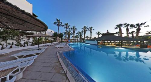 a swimming pool with chairs and umbrellas at a resort at Parkim Ayaz Hotel in Gümbet