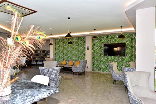 a lobby with chairs and a table and a tv at Parkim Ayaz Hotel in Gümbet