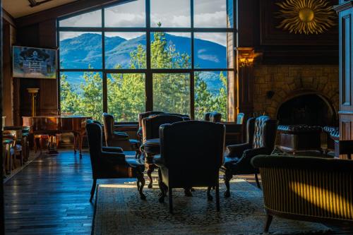 a room with chairs and a fireplace and a large window at Maxi Park Hotel & Spa in Velingrad