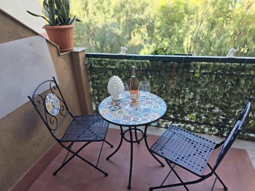 a table and two chairs on a balcony at Destinazione Mare Naxos in Giardini Naxos