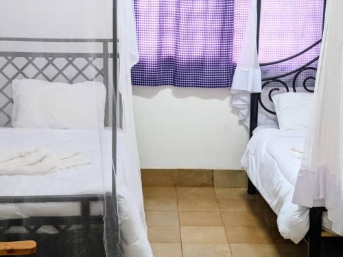 a room with two beds and a window at STC.SAFARI LODGE in Oldeani
