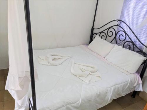 a bed with white sheets and white pillows on it at STC.SAFARI LODGE in Oldeani