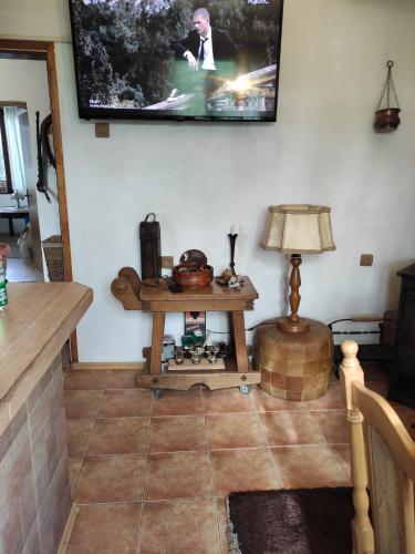 Una sala de estar con una mesa y un televisor en la pared. en Guest house Charodea, en Kipilovo