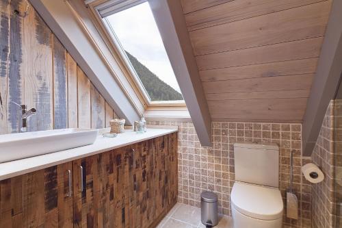łazienka z toaletą, umywalką i oknem w obiekcie LUDERNA - Dúplex Pin Nere w mieście Salardú