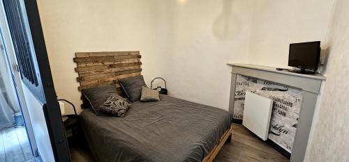 une petite chambre avec un lit et une télévision dans l'établissement Ruisseau & Fleur..., à Saint-Martin-dʼAblois