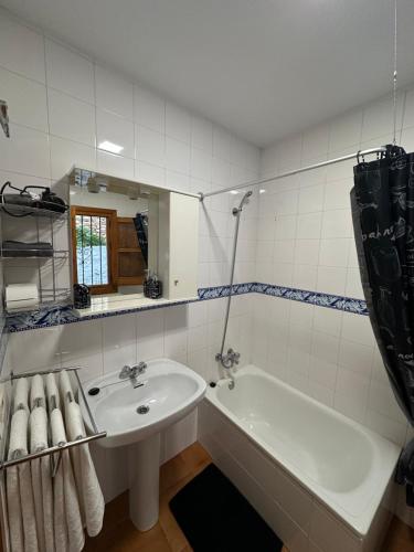 a white bathroom with a tub and a sink at Las Vistas in Bubión