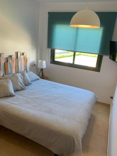 a bedroom with a large white bed with a window at Apartamento de estilo mediterráneo in Miami Platja