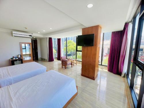 a bedroom with two beds and a flat screen tv at Happy Light Central Nha Trang in Nha Trang