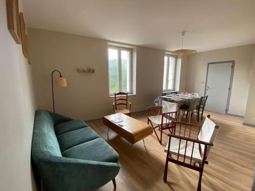a living room with a green couch and a table at Appartement T4 et Parking à 3km du Futuroscope in Jaunay-Marigny