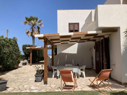 um pátio de uma casa com uma mesa e cadeiras em Posidonia Apartments em Marsala
