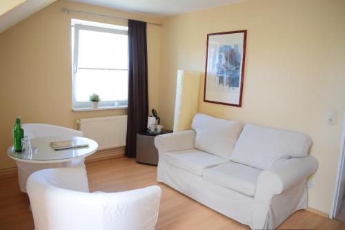 uma sala de estar com um sofá branco e uma janela em Hotel Seeburg em Sankt Peter-Ording
