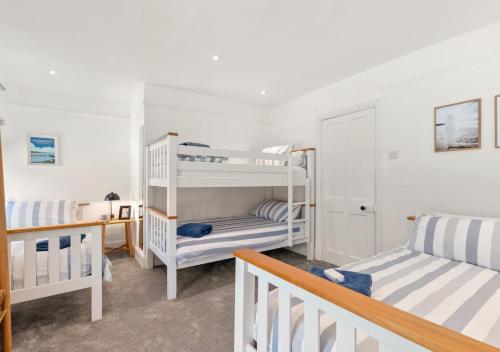 a bedroom with two bunk beds and a staircase at Enfield House in Saundersfoot