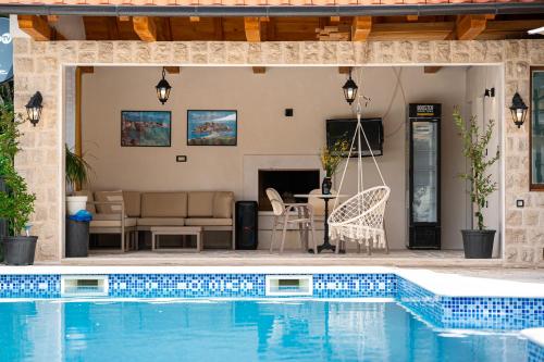 a house with a swimming pool and a patio at Sunset & Sunrise Villas in Stanisici-Two Villas With Common Pool in Budva