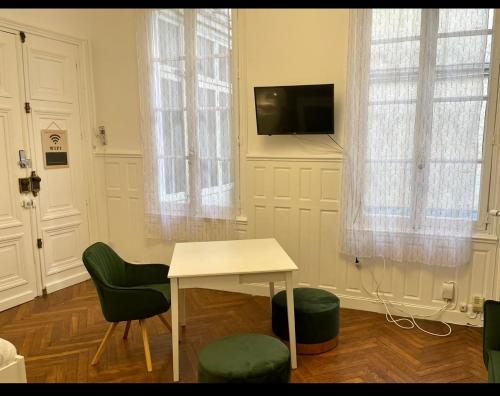 - un salon avec une table, des chaises et une télévision dans l'établissement Spacieux Studio * Hyper Centre *, à Orléans