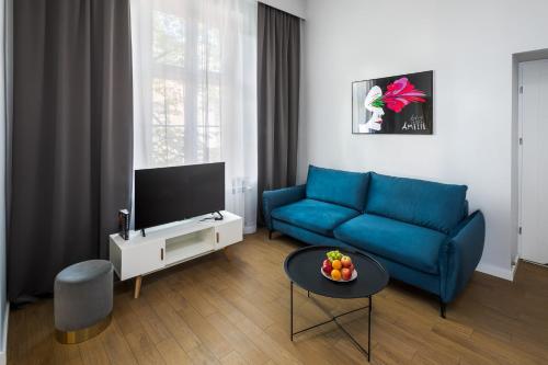 un soggiorno con divano blu e TV di Modern & cozy flat - near to Wawel Castle a Cracovia