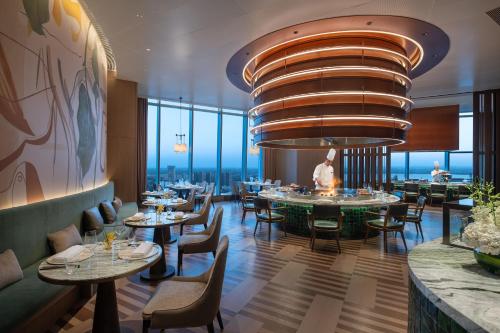 a restaurant with tables and chairs and a large chandelier at Hyatt Regency Changshu Kuncheng Lake in Changshu