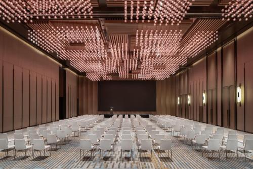 a large room with white tables and chairs and chandeliers at Hyatt Regency Changshu Kuncheng Lake in Changshu