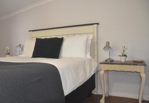 a bedroom with a bed and a table with a lamp at 62 on Adderley in George