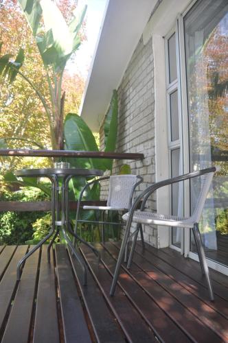a pair of chairs and a table on a porch at 62 on Adderley in George