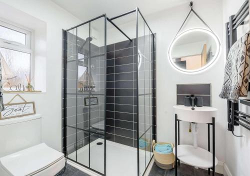 a bathroom with a glass shower stall and a sink at The Hideaway in Blaencelyn