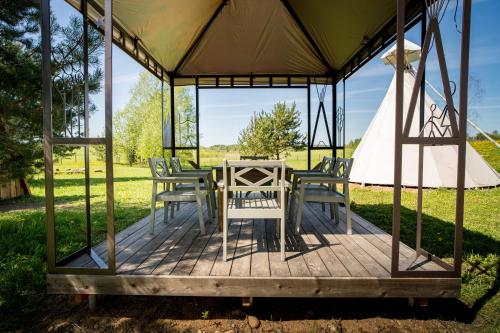 a wooden deck with a table and chairs in a gazebo at Briedžio sapnas in Sudervė