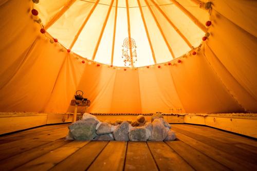 a tent with a stuffed animal laying on a wooden floor at Briedžio sapnas in Sudervė