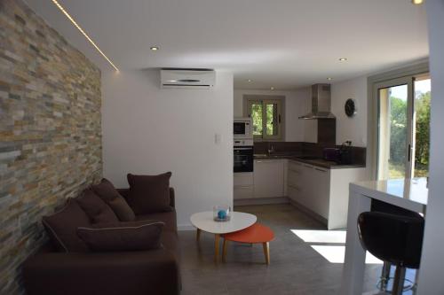 un salon avec un canapé et une table dans l'établissement Superbe rez-de-jardin de villa MACCHIA 2, Proche des plages de Santa giulia, à Porto-Vecchio