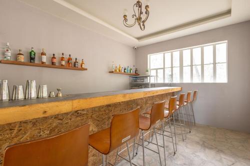 a bar with a row of chairs in a room at Mosaic Liwliwa Hotel Near Beach in Zambales