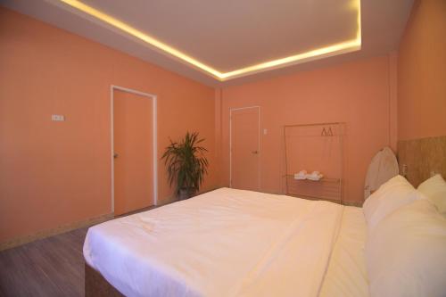 a large white bed in a room with orange walls at Mosaic Liwliwa Hotel Near Beach in Zambales