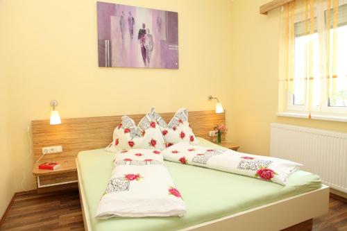 a bedroom with two beds with white and red pillows at Apartmenthaus Franz Kleindienst in Deutschlandsberg