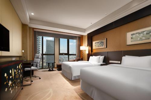 a hotel room with two beds and a television at The Westin Hefei Baohe in Hefei