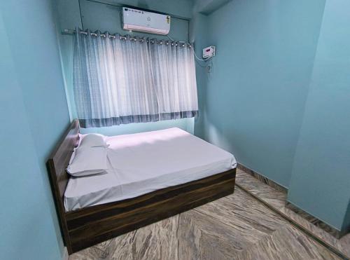 a small room with a bed in a blue room at Sunrise Guest House in Jaipur