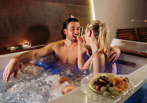 a man and a woman in a bath tub at Hotel Tri Studničky - Adult friendly in Demanovska Dolina