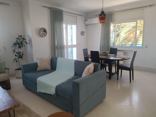 纳布勒Superbe étage de villa vue sur mer的客厅里有一张蓝色的沙发和一张桌子