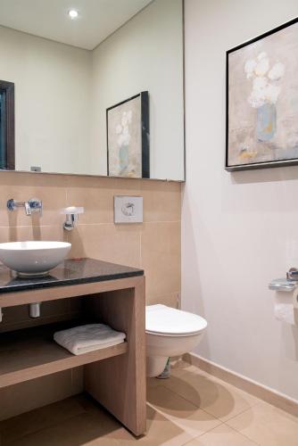 a bathroom with a sink and a toilet at Anahita - Appartement Golf View - Hole 9 in Beau Champ