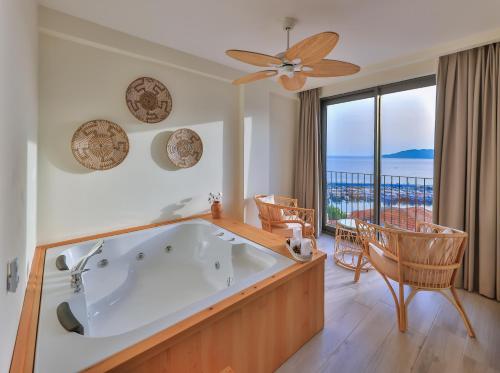 a bath tub in a room with a view of the ocean at Kas Athena Hotel in Kas
