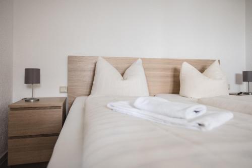 um quarto com 2 camas com lençóis brancos e almofadas em Toschis Station-Motel-Wirtshaus-an der Autobahn-Bowling em Zella-Mehlis