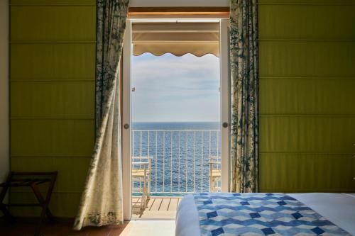 a bedroom with a window with a view of the ocean at Taverna Del Capitano in Massa Lubrense