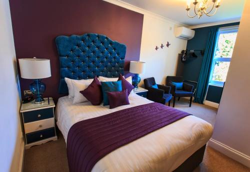 1 dormitorio con 1 cama grande y cabecero azul en The 25 Boutique B&B - Adults Only, en Torquay