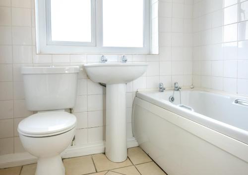 a bathroom with a toilet and a sink and a bath tub at 15 Lon Cernyw in Abersoch