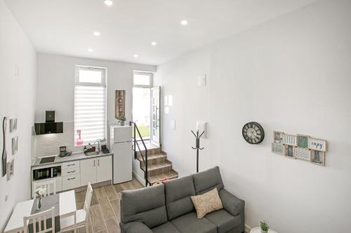 a living room with a couch and a table and a kitchen at Loft El Ramonal in Candelaria