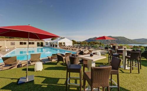 un resort con piscina, tavoli e ombrelloni di Studio de charme à 300 m de la Plage de Santa Giulia a Porto Vecchio