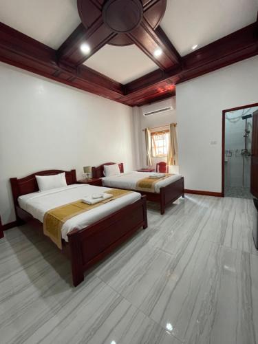 een slaapkamer met 2 bedden en een plafondventilator bij PhaiLin Hotel in Luang Prabang
