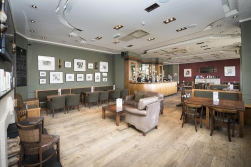 a restaurant with chairs and tables and a bar at Columba Hotel Inverness by Compass Hospitality in Inverness
